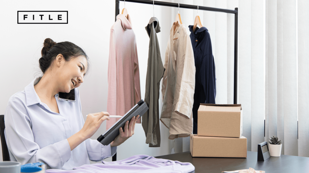 Femme au téléphone, en train de valider une commande en ligne, dans son bureau, avec un porte-manteau visible.